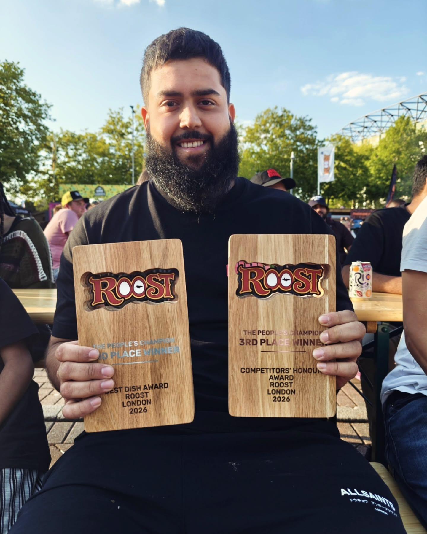 Hot Bird team member holding two Roost Chicken Fest trophies